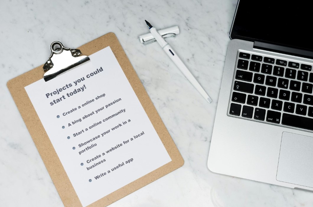 A checklist of things to do for an ad-network next to a laptop on a desk.