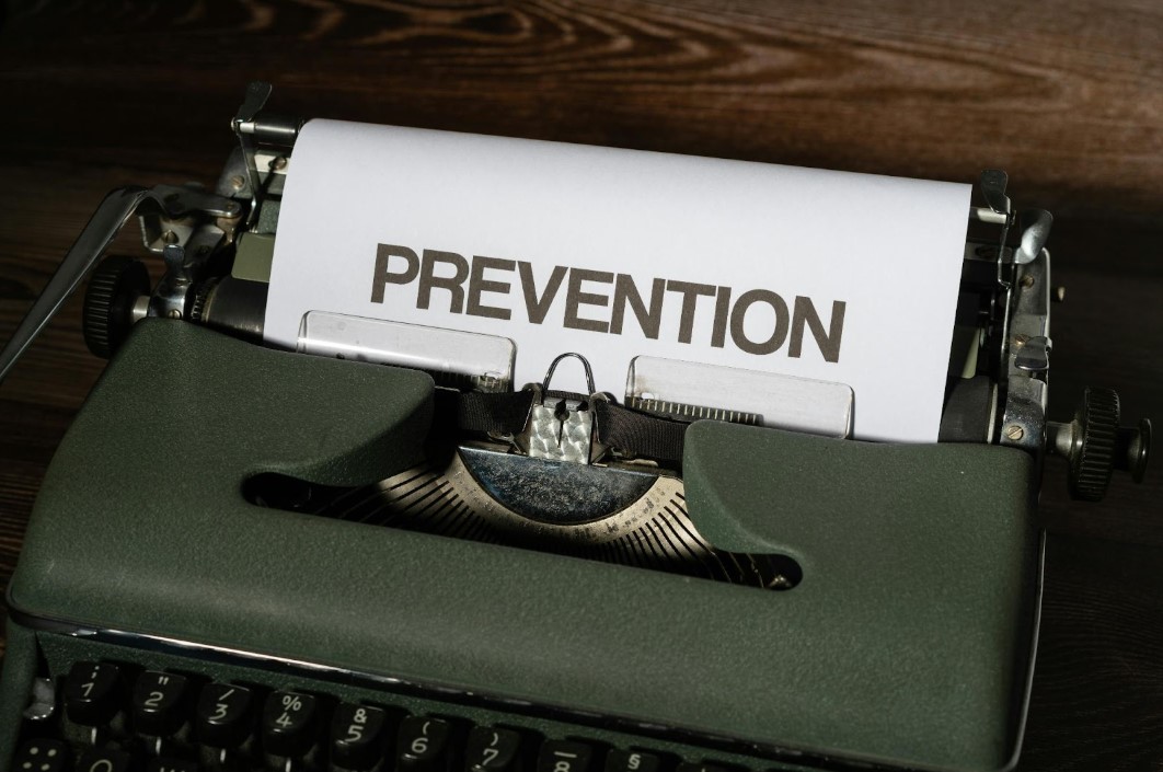 The word "PREVENTION" on a peice of paper coming out of an old school typewriter.
